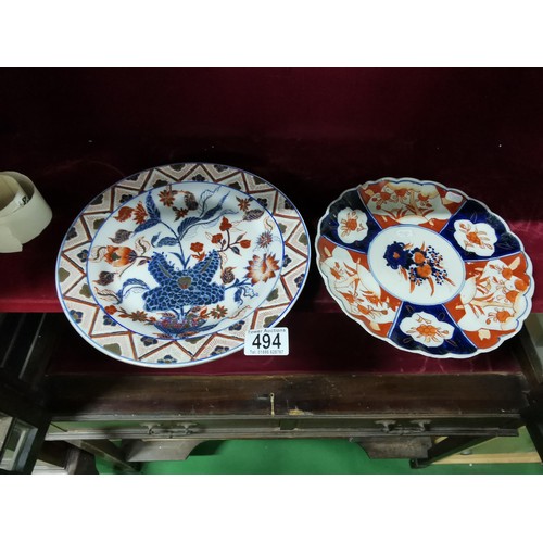 494 - A pair of Oriental plates, larger plate is hand decorated with oriental marks at the base, floral de... 