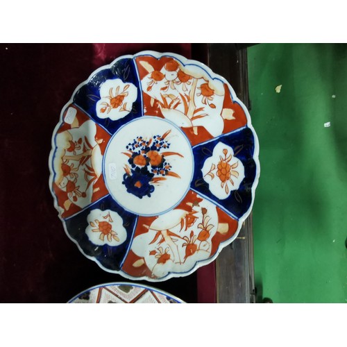 494 - A pair of Oriental plates, larger plate is hand decorated with oriental marks at the base, floral de... 