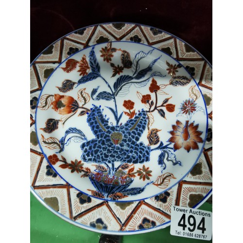494 - A pair of Oriental plates, larger plate is hand decorated with oriental marks at the base, floral de... 