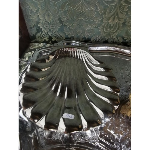 497 - A quantity of plated ware including a plated butlers tray, two large scalloped form dishes, a set of... 