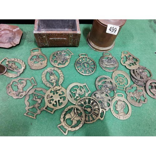 499 - A quantity of brass and copper items including two large copper goblets a quantity of horse brasses ... 