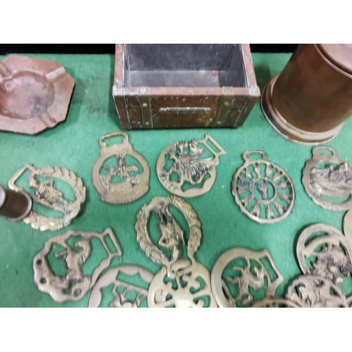 499 - A quantity of brass and copper items including two large copper goblets a quantity of horse brasses ... 