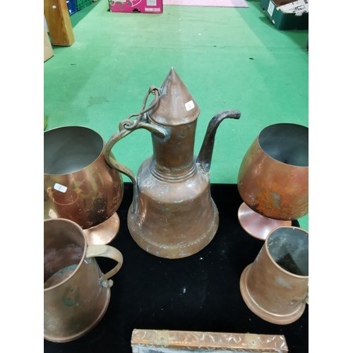 499 - A quantity of brass and copper items including two large copper goblets a quantity of horse brasses ... 