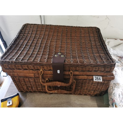 264 - A wicker picnic basket along with a wicker tray. Containing two double duvet cover and pillow cases,... 