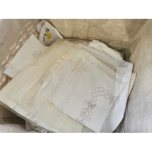 265 - A wicker lined linen basket, containing a quantity of traced needle work, table cloths, table centre... 