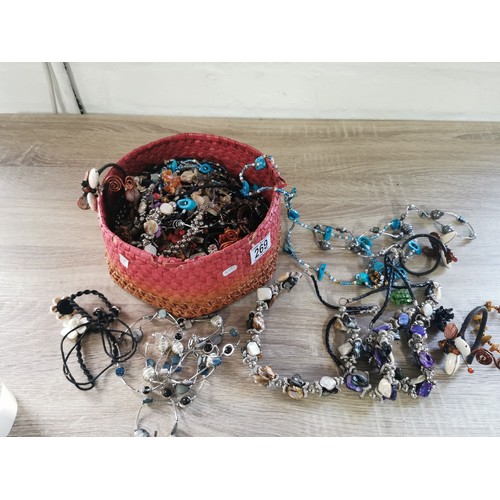 269 - A small hand made basket containing a large quantity of costume jewellery, including necklaces and b... 