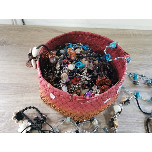 269 - A small hand made basket containing a large quantity of costume jewellery, including necklaces and b... 