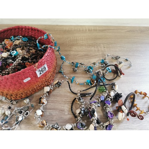 269 - A small hand made basket containing a large quantity of costume jewellery, including necklaces and b... 