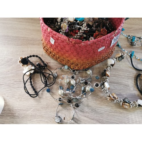 269 - A small hand made basket containing a large quantity of costume jewellery, including necklaces and b... 