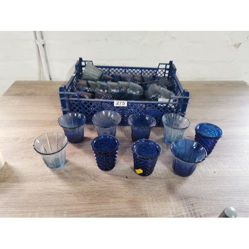 275 - A quantity of 32 blue glass tea lights with various designs.