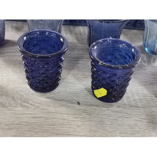 275 - A quantity of 32 blue glass tea lights with various designs.