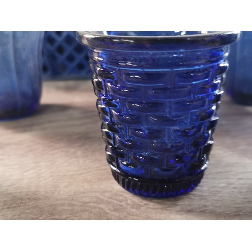 275 - A quantity of 32 blue glass tea lights with various designs.