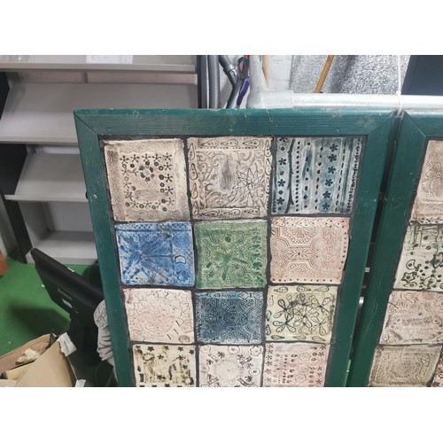 529 - Three wooden panels of naive tile art, each panel containing eighteen handmade, hand decorated tiles... 
