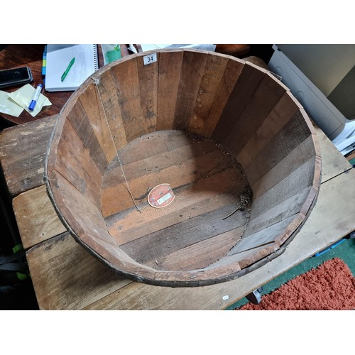 34 - Large wooden barrel formed planter in good condition. Height of 35cm x diameter 66cm