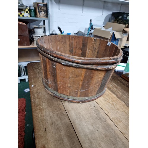 34 - Large wooden barrel formed planter in good condition. Height of 35cm x diameter 66cm