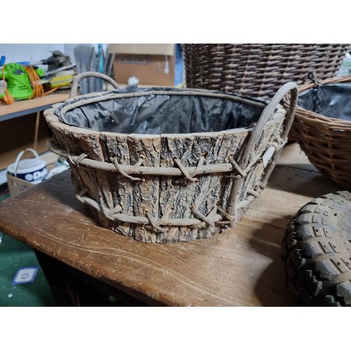 39 - Large quantity of various wicker baskets along with a hand made wooden basket and a wheelbarrow tyre... 