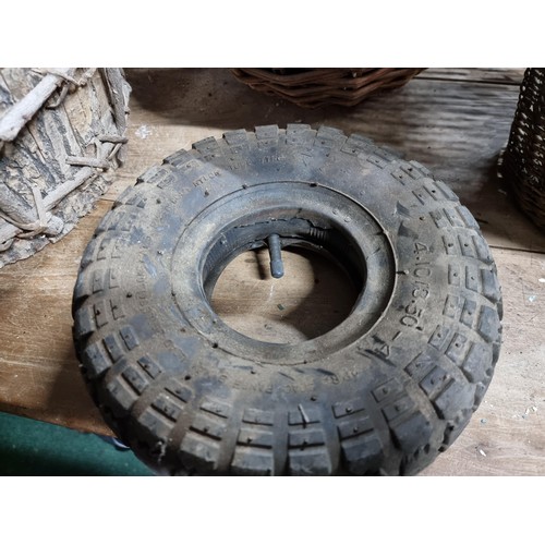 39 - Large quantity of various wicker baskets along with a hand made wooden basket and a wheelbarrow tyre... 