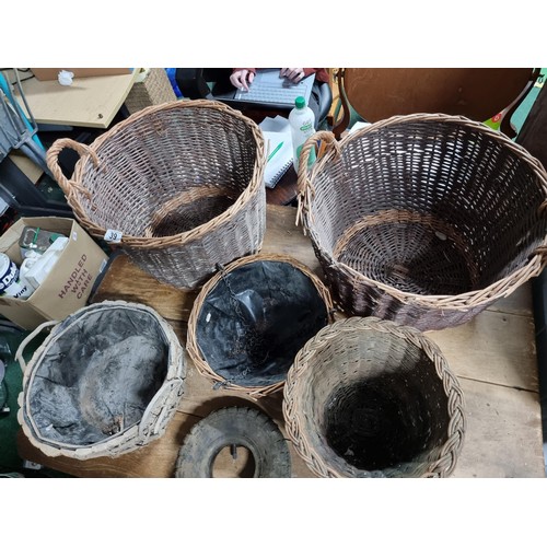 39 - Large quantity of various wicker baskets along with a hand made wooden basket and a wheelbarrow tyre... 