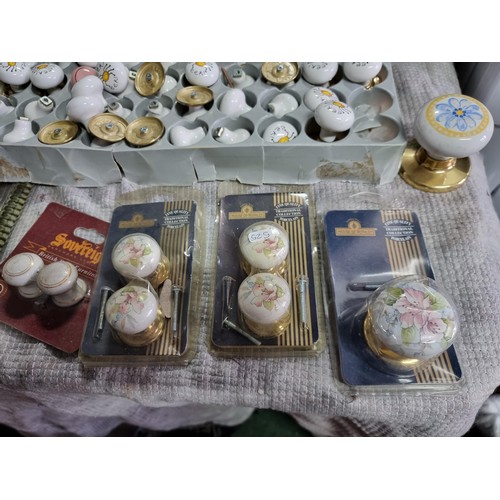 75 - 2x boxes full of various ceramic door and drawer knobs with various designs along with a large quant... 