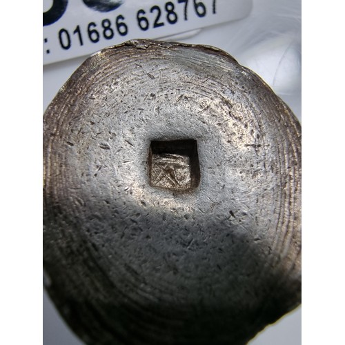339 - An unusual lump of solid silver with an impressed square stamp appearing to have Asian character mar... 
