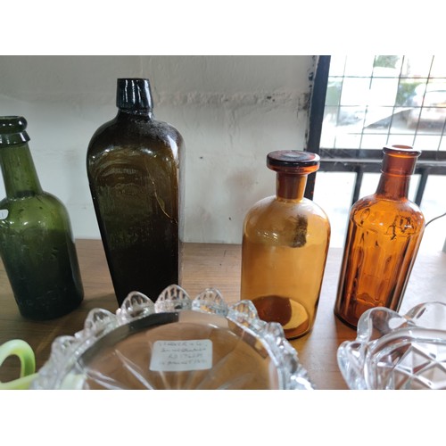 133 - A quantity of vintage glassware including coloured beer bottles, poison bottles along with 2 Sunderl... 