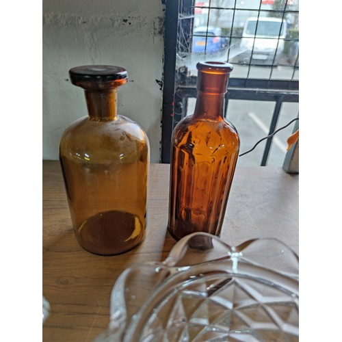 133 - A quantity of vintage glassware including coloured beer bottles, poison bottles along with 2 Sunderl... 