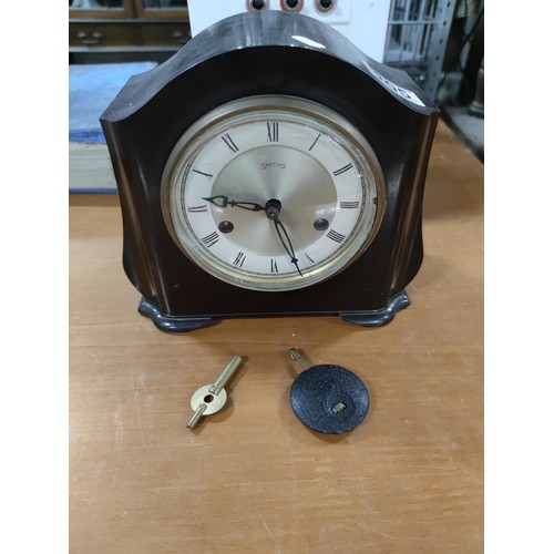 205 - A vintage Smiths bakelite mantel clock complete with pendulum and key, striking on gong rods in full... 