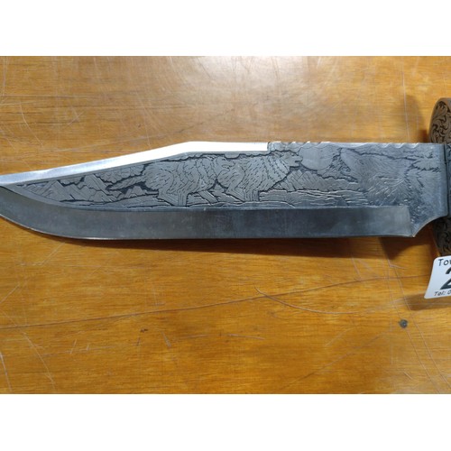 222 - A very ornate bowie knife with resin handle blade is carved with wolf designs and handle has carving... 