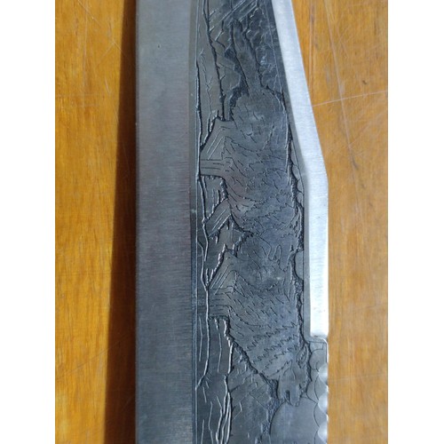 222 - A very ornate bowie knife with resin handle blade is carved with wolf designs and handle has carving... 