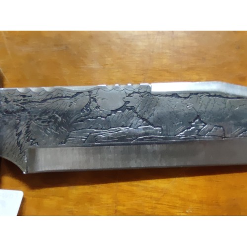 222 - A very ornate bowie knife with resin handle blade is carved with wolf designs and handle has carving... 