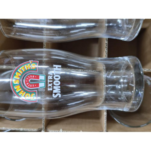 297 - A box containing 37 John Smiths Extra Smooth pint glasses in a segmented box.