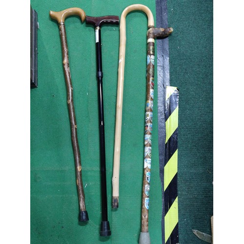 315 - A collection of 4 walking sticks including a collapsible mobility aid stick, one contains a large qu... 