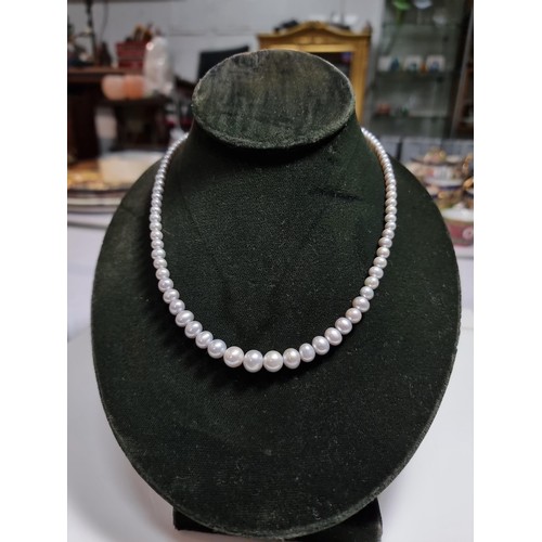 407 - A fine quality natural sea pearl (not cultured) beaded necklace with graduated beads featuring an im... 