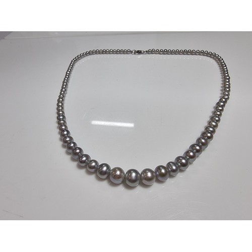 407 - A fine quality natural sea pearl (not cultured) beaded necklace with graduated beads featuring an im... 