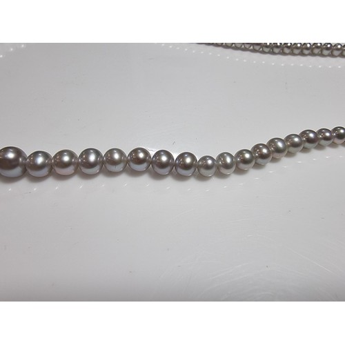 407 - A fine quality natural sea pearl (not cultured) beaded necklace with graduated beads featuring an im... 