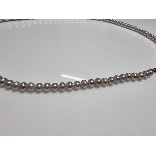 407 - A fine quality natural sea pearl (not cultured) beaded necklace with graduated beads featuring an im... 