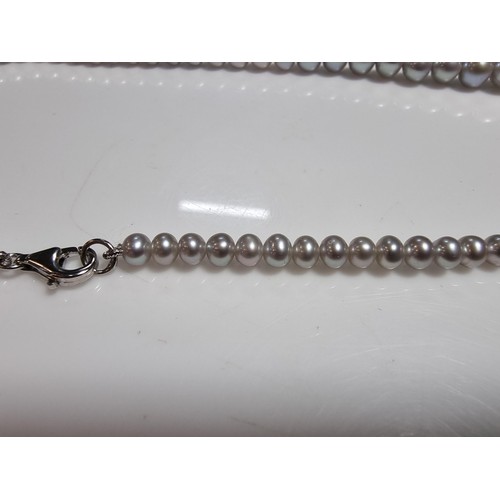 407 - A fine quality natural sea pearl (not cultured) beaded necklace with graduated beads featuring an im... 