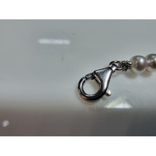 407 - A fine quality natural sea pearl (not cultured) beaded necklace with graduated beads featuring an im... 
