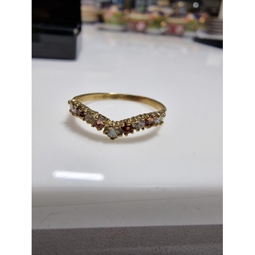 405 - A hallmarked 9ct yellow gold wishbone ring inset with orange and white cz crystal stones. In excelle... 