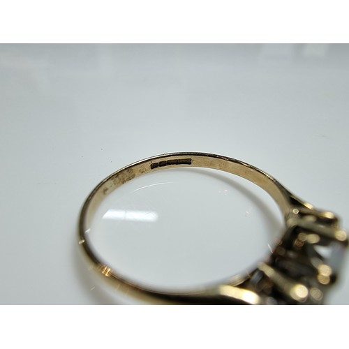 412 - A hallmarked 9ct yellow gold ring inset with an opal cabochon, flanked by 2 small diamonds. Clean, i... 