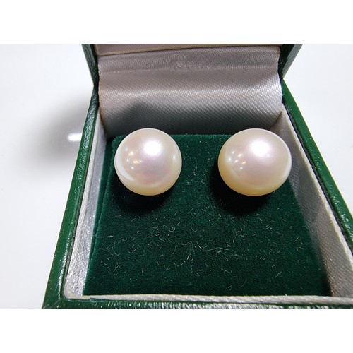 413 - A pair of 9ct yellow gold large genuine pearl stud earrings complete with butterfly backs in good co... 