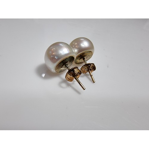 413 - A pair of 9ct yellow gold large genuine pearl stud earrings complete with butterfly backs in good co... 