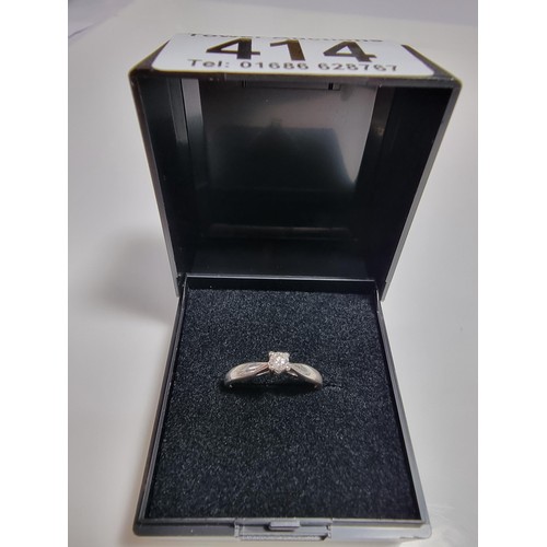 414 - A hallmarked 9ct white gold solitaire diamond ring inset with a 0.10 ct diamond which is sparkly and... 