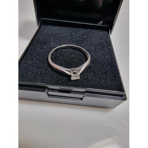 414 - A hallmarked 9ct white gold solitaire diamond ring inset with a 0.10 ct diamond which is sparkly and... 