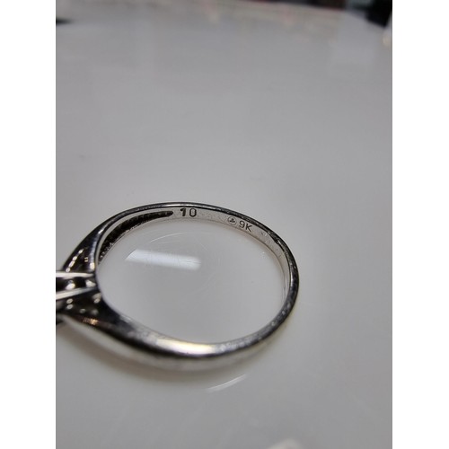 414 - A hallmarked 9ct white gold solitaire diamond ring inset with a 0.10 ct diamond which is sparkly and... 