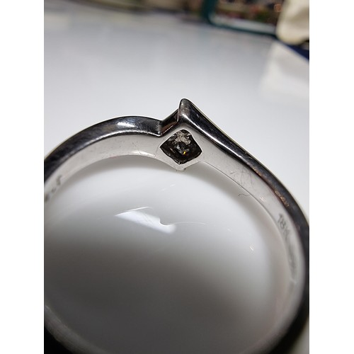 419 - An 18ct white gold solitaire diamond ring inset with 4  square cut diamonds 0.24ct in total which ar... 