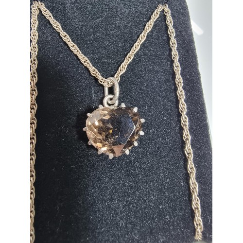 355 - A 925 silver pendant inset with a large faceted heart formed smokey quartz gemstone. Set on a 16