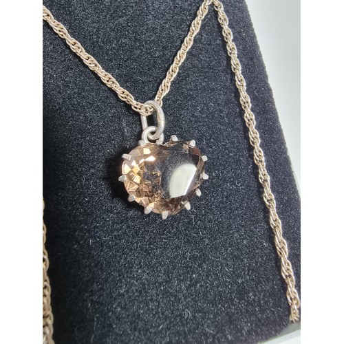 355 - A 925 silver pendant inset with a large faceted heart formed smokey quartz gemstone. Set on a 16