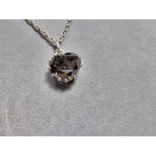 355 - A 925 silver pendant inset with a large faceted heart formed smokey quartz gemstone. Set on a 16
