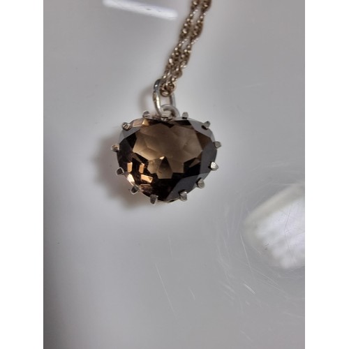 355 - A 925 silver pendant inset with a large faceted heart formed smokey quartz gemstone. Set on a 16